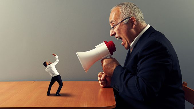 Man shouting at tiny man with mega phone