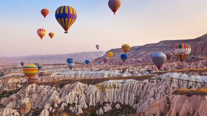 Hot air balloon flying over rock landscape at Cappadocia Turkey