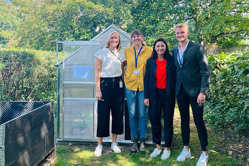 4 people Standing in front of greenhouse