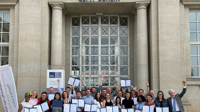 ETP participants holding certificate in front of ESMT Berlin building