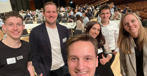 Selfie photo of 4 males and two females at a conference