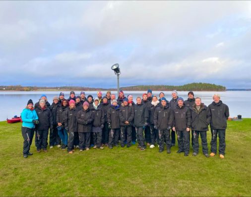 Group photo in photo in front of lake