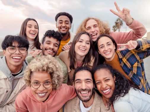 Multi ethnic men and women taking selfie outdoors with backlight