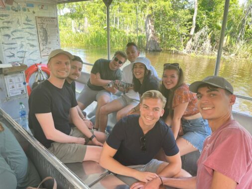 Group of young interns on boat trip, posing for group photo